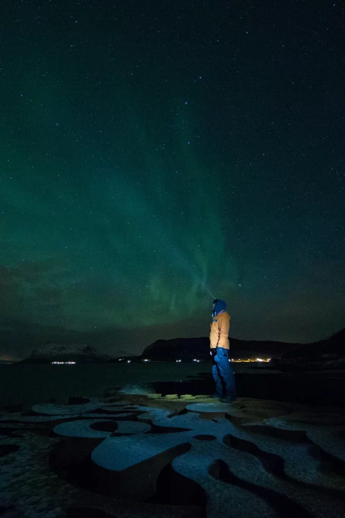 Torch lighting the sky under the northern lights